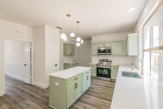 7205 Coventry Cir, North Richland Hills, TX 76182 - kitchen with appliances with stainless steel finishes, green cabinetry, a sink, light wood-style flooring, and recessed lighting