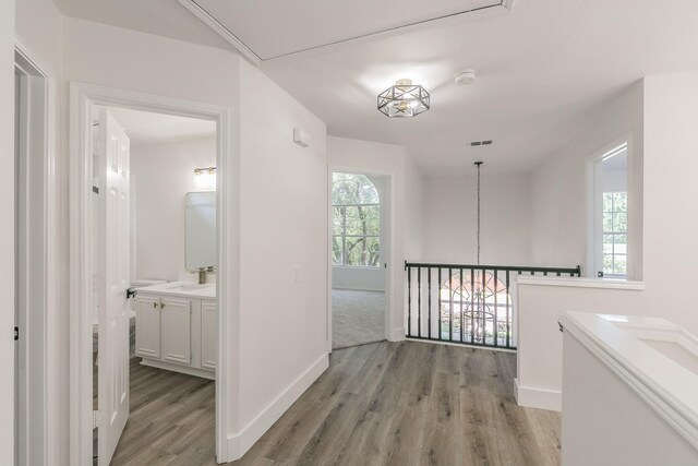 7205 Coventry Cir, North Richland Hills, TX 76182 - corridor featuring light wood-style floors, baseboards, and a sink
