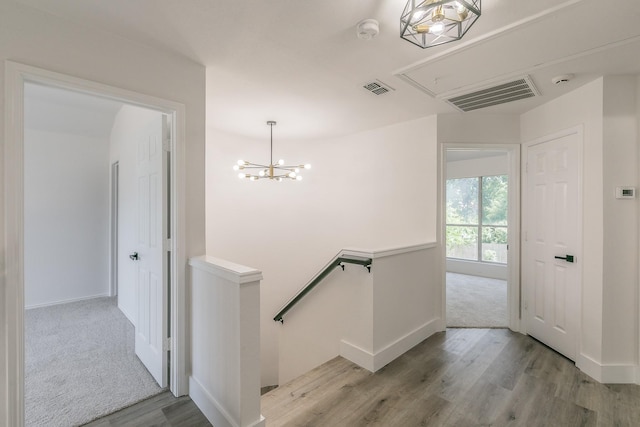 7205 Coventry Cir, North Richland Hills, TX 76182 - hall featuring an upstairs landing, attic access, wood finished floors, baseboards, and a chandelier