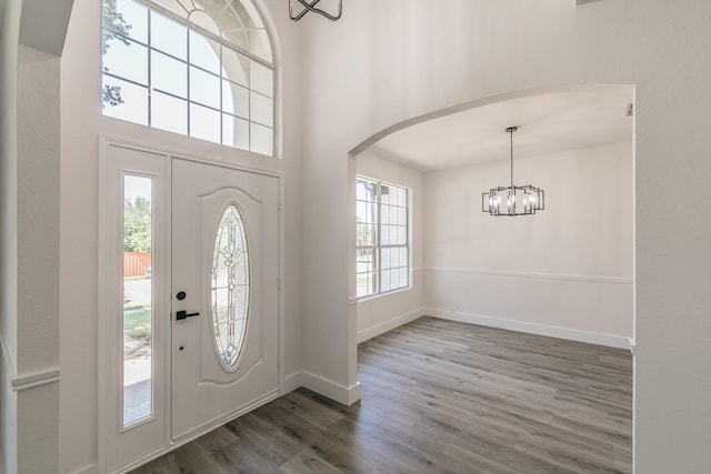 7205 Coventry Cir, North Richland Hills, TX 76182 - foyer entrance with a chandelier, wood finished floors, arched walkways, baseboards, and a towering ceiling