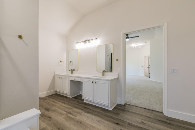 7205 Coventry Cir, North Richland Hills, TX 76182 - bathroom with lofted ceiling, double vanity, wood finished floors, and baseboards