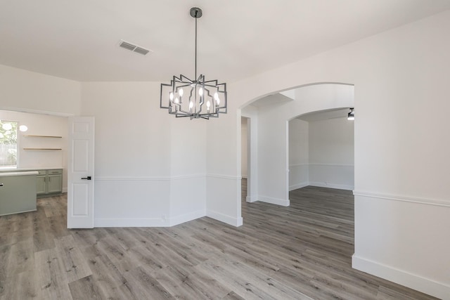 7205 Coventry Cir, North Richland Hills, TX 76182 - spare room featuring light wood-style flooring, arched walkways, a chandelier, baseboards, and ceiling fan