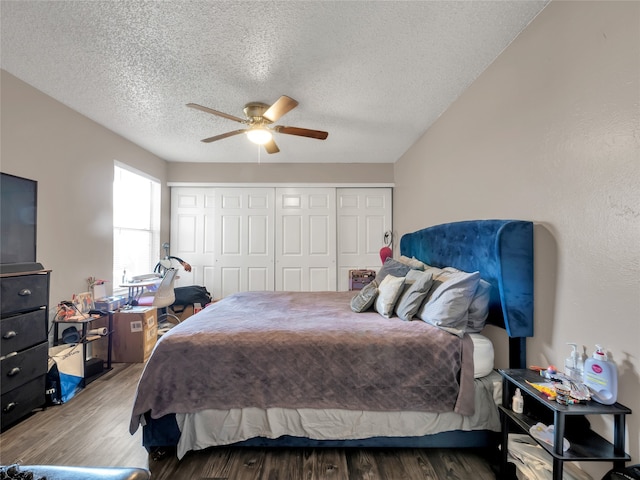 9170 Forest Ln Unit 228, Dallas, TX 75243 - bedroom featuring a textured ceiling, wood finished floors, a closet, and a ceiling fan