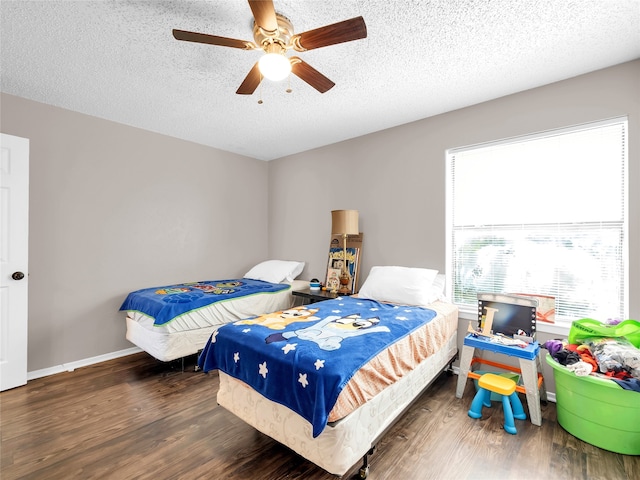 9170 Forest Ln Unit 228, Dallas, TX 75243 - bedroom with wood finished floors, a textured ceiling, ceiling fan, and baseboards