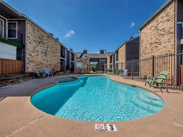 9170 Forest Ln Unit 228, Dallas, TX 75243 - view of swimming pool with a patio area and a pool with connected hot tub