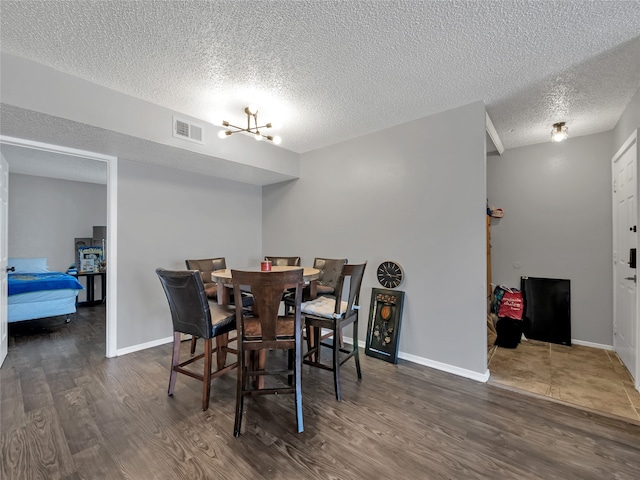 9170 Forest Ln Unit 228, Dallas, TX 75243 - dining space with wood finished floors, a textured ceiling, and baseboards