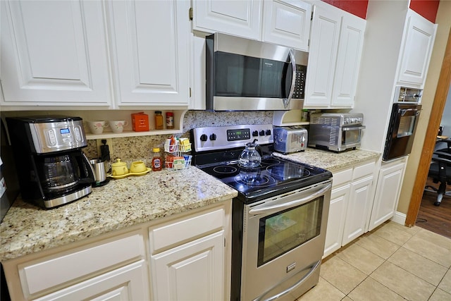 312 W Pleasantview Dr, Hurst, TX 76054 - kitchen featuring stainless steel appliances, light tile patterned floors, and white cabinets