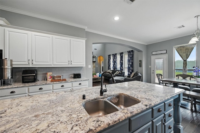 408 Mission Dr, Forney, TX 75126 - kitchen with a sink, arched walkways, white cabinets, ornamental molding, and decorative backsplash