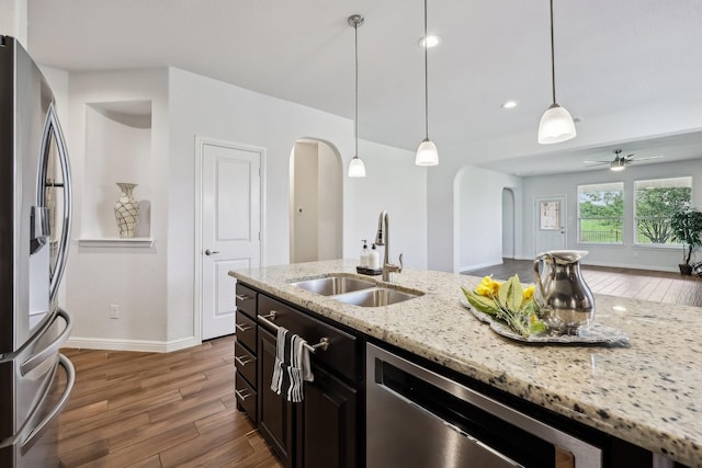 632 Dunster Ln, Saginaw, TX 76131 - kitchen featuring arched walkways, a sink, stainless steel appliances, wood finished floors, and recessed lighting