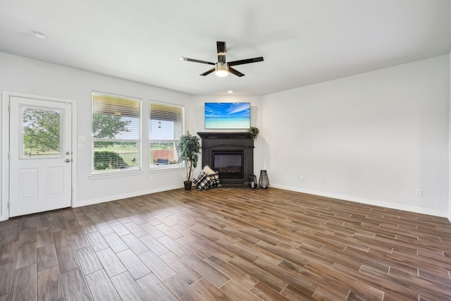 632 Dunster Ln, Saginaw, TX 76131 - unfurnished living room featuring a glass covered fireplace, plenty of natural light, ceiling fan, and wood finished floors