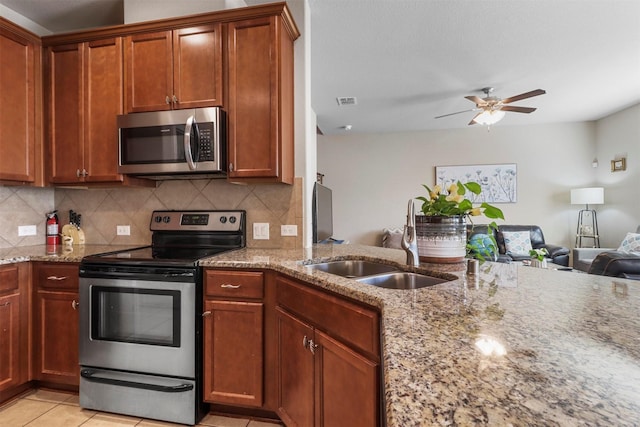 316 Tallgrass Ln, Plano, TX 75023 - kitchen with appliances with stainless steel finishes, a sink, light stone countertops, ceiling fan, and open floor plan