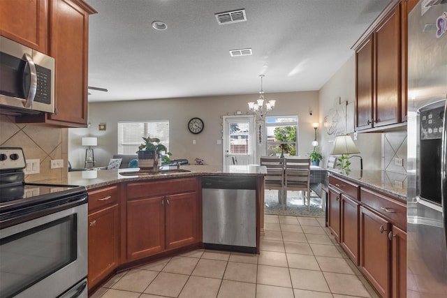 316 Tallgrass Ln, Plano, TX 75023 - kitchen with stainless steel appliances, a sink, a chandelier, tasteful backsplash, and a peninsula