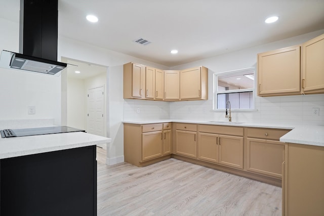 6625 Bridges Ave, Richland Hills, TX 76118 - kitchen featuring wall chimney range hood, a sink, light brown cabinetry, black electric stovetop, and light wood-style floors