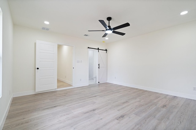 6625 Bridges Ave, Richland Hills, TX 76118 - unfurnished bedroom with a barn door, light wood-type flooring, recessed lighting, baseboards, and a ceiling fan
