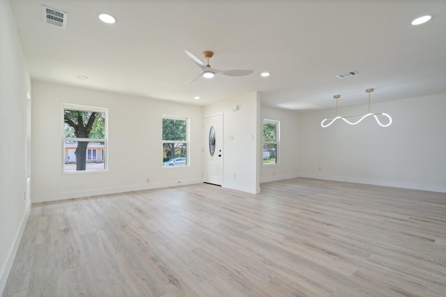 6625 Bridges Ave, Richland Hills, TX 76118 - unfurnished living room with light wood finished floors, recessed lighting, baseboards, a ceiling fan, and a chandelier