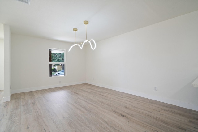 6625 Bridges Ave, Richland Hills, TX 76118 - spare room featuring light wood-style floors, a chandelier, and baseboards