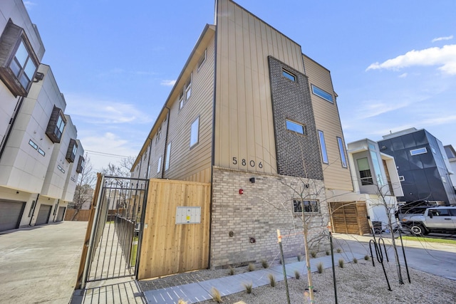 5806 Bryan Pkwy Unit 4, Dallas, TX 75206 - view of home's exterior with a gate, board and batten siding, and brick siding