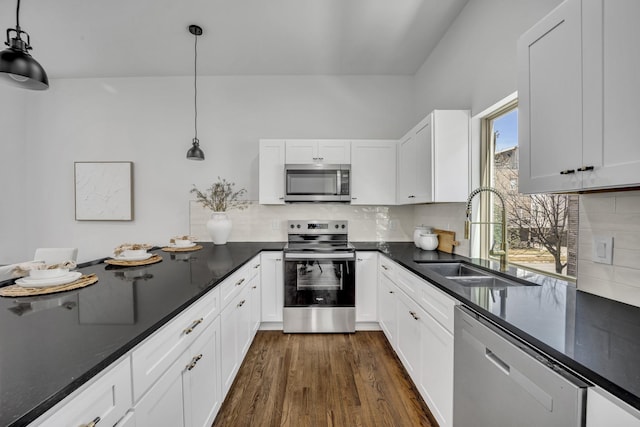 5806 Bryan Pkwy Unit 4, Dallas, TX 75206 - kitchen with appliances with stainless steel finishes, a sink, dark countertops, dark wood-type flooring, and pendant lighting