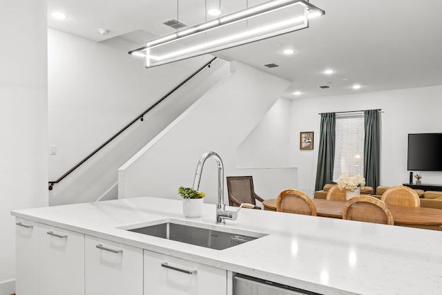 1928 Kearney Ct, Dallas, TX 75204 - kitchen with a sink, recessed lighting, white cabinets, open floor plan, and light stone countertops
