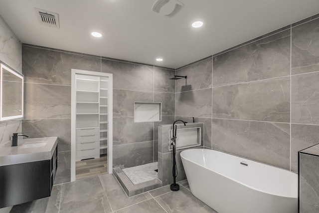1103 Teakwood Dr, Duncanville, TX 75137 - bathroom with tile walls, a tile shower, a freestanding bath, vanity, and marble finish flooring