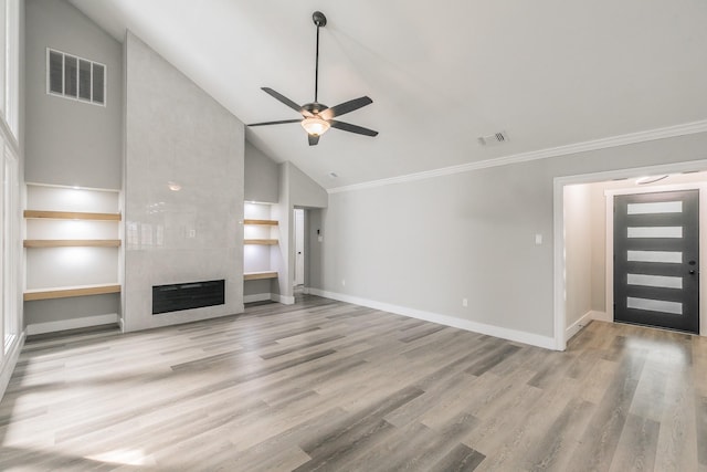1103 Teakwood Dr, Duncanville, TX 75137 - unfurnished living room featuring ceiling fan, crown molding, a tile fireplace, wood finished floors, and high vaulted ceiling