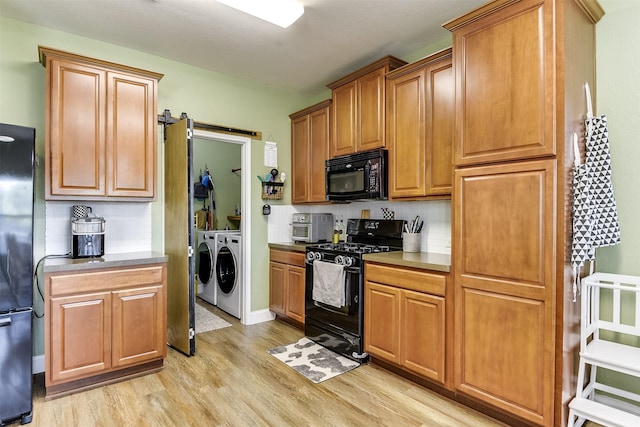 712 Saddleway Dr, Fort Worth, TX 76179 - kitchen featuring black appliances, washing machine and clothes dryer, light wood-type flooring, and backsplash