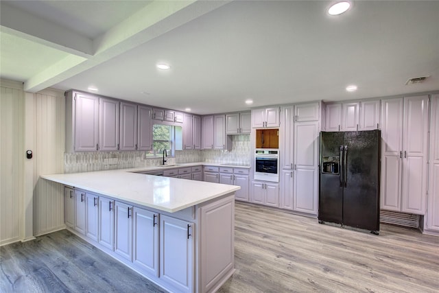 552 Oak Leaf Trl, East Tawakoni, TX 75472 - kitchen featuring black fridge, wall oven, a sink, a peninsula, and tasteful backsplash