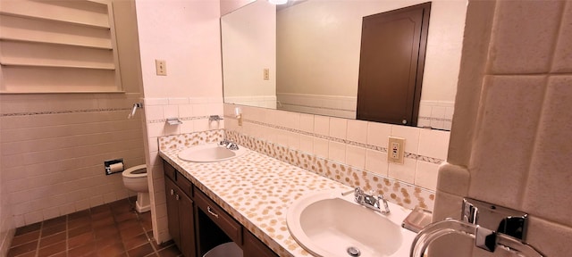 6121 Over Lake Dr, Fort Worth, TX 76135 - bathroom featuring tile walls, double vanity, toilet, tile patterned floors, and wainscoting