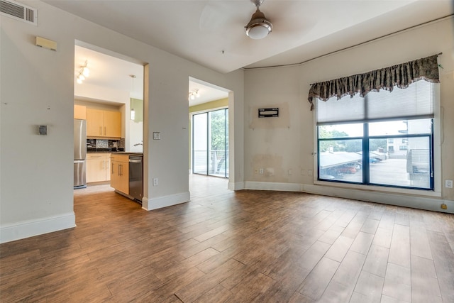 4414 Cedar Springs Rd Unit 226, Dallas, TX 75219 - unfurnished living room featuring a ceiling fan, wood finished floors, and baseboards