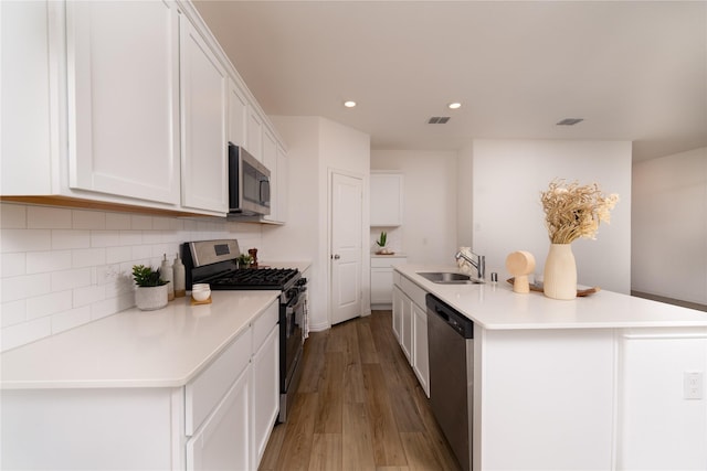 1236 Sequoia Ln, Princeton, TX 75407 - kitchen with appliances with stainless steel finishes, a sink, light wood-style floors, backsplash, and white cabinets
