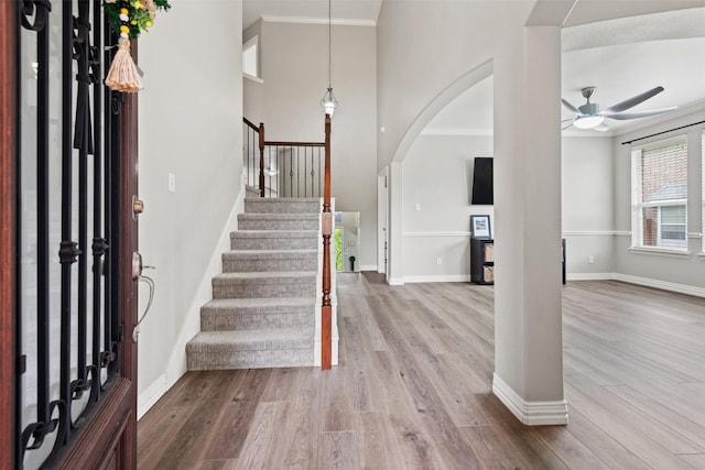 3516 Horace Ave, Fort Worth, TX 76244 - entrance foyer featuring ceiling fan, wood finished floors, arched walkways, crown molding, and stairway