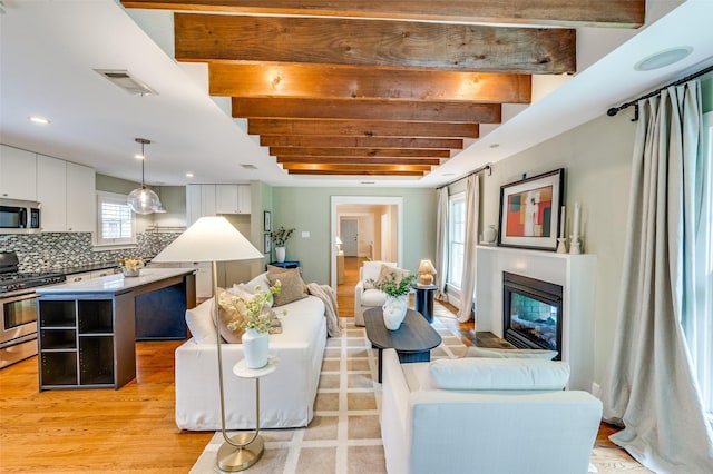 7107 La Vista Dr, Dallas, TX 75214 - living area with a glass covered fireplace, light wood-type flooring, beamed ceiling, and recessed lighting