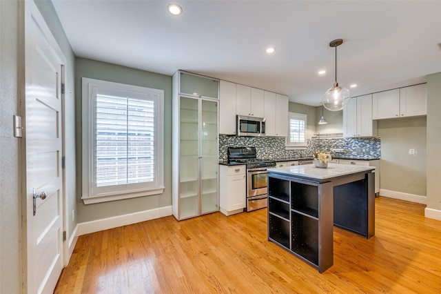 7107 La Vista Dr, Dallas, TX 75214 - kitchen featuring stainless steel appliances, baseboards, decorative backsplash, light wood-style floors, and recessed lighting