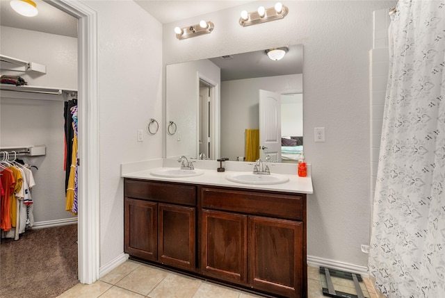 2841 Pacifico Way, Fort Worth, TX 76111 - full bathroom with double vanity, a spacious closet, tile patterned flooring, curtained shower, and baseboards