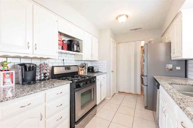 1654 Clarendon Dr, Lewisville, TX 75067 - kitchen featuring stainless steel appliances, decorative backsplash, white cabinetry, and light tile patterned flooring