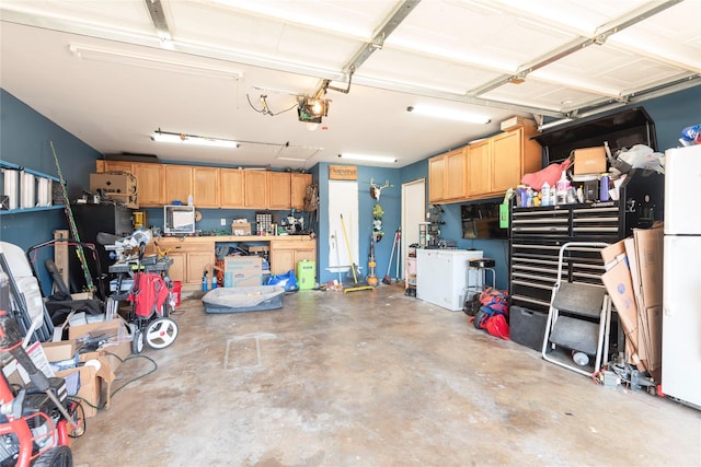 1654 Clarendon Dr, Lewisville, TX 75067 - garage with freestanding refrigerator, a workshop area, and a garage door opener