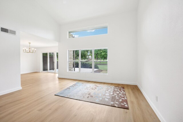 2926 Shady Lake Cir, Carrollton, TX 75006 - unfurnished room featuring a chandelier, light wood-style flooring, plenty of natural light, and a high ceiling