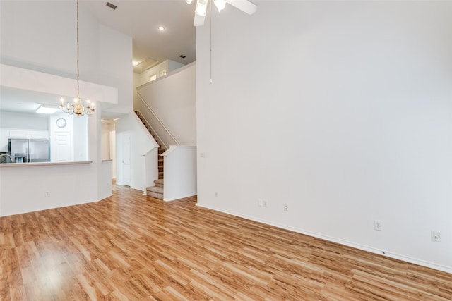 7001 Van Gogh Dr, Plano, TX 75093 - unfurnished living room with light wood-style flooring, a chandelier, stairs, a ceiling fan, and baseboards