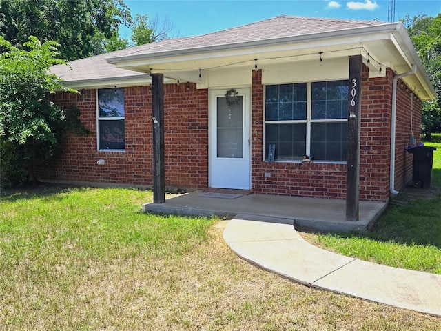 306 S Allen St, Boyd, TX 76023 - view of front facade with brick siding, a front lawn, and roof with shingles