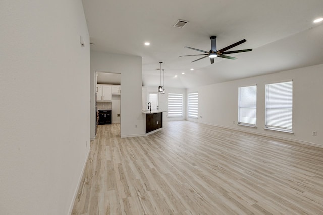 15525 Western Trl, Frisco, TX 75035 - unfurnished living room with ceiling fan, recessed lighting, light wood-style flooring, baseboards, and a sink
