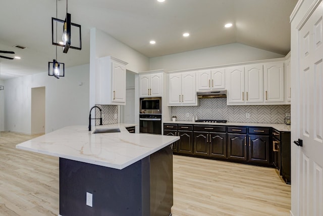 15525 Western Trl, Frisco, TX 75035 - kitchen with oven, a sink, stainless steel microwave, white cabinetry, and under cabinet range hood