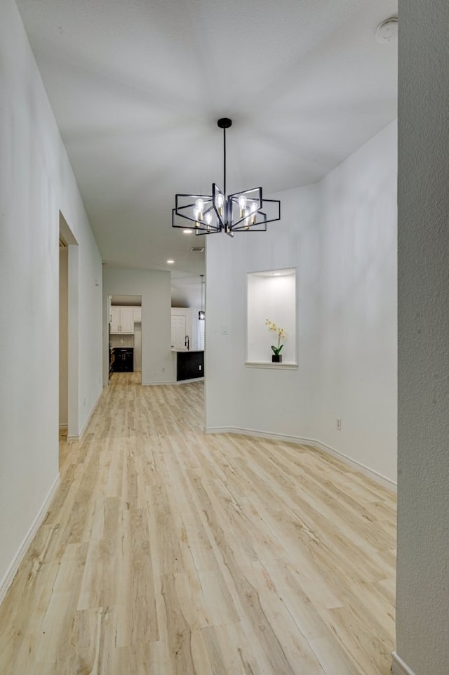 15525 Western Trl, Frisco, TX 75035 - unfurnished dining area with light wood-type flooring, a chandelier, and baseboards