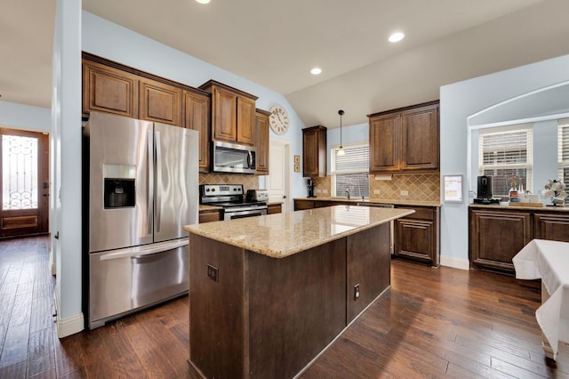 3214 Paisley Dr, Midlothian, TX 76065 - kitchen featuring stainless steel appliances, healthy amount of natural light, a kitchen island, vaulted ceiling, and light stone counters