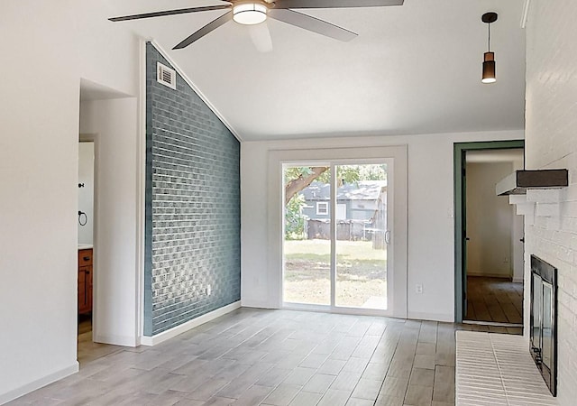 409 Fleming Dr, Hurst, TX 76053 - unfurnished living room with vaulted ceiling, ceiling fan, a brick fireplace, wood finished floors, and baseboards