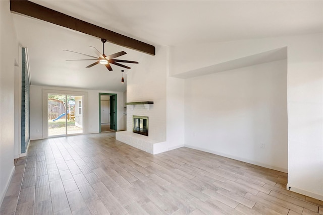 409 Fleming Dr, Hurst, TX 76053 - unfurnished living room with a ceiling fan, beamed ceiling, a fireplace, light wood finished floors, and baseboards