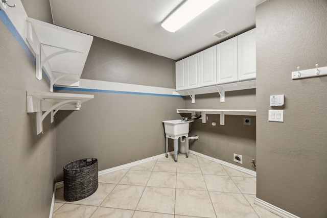 308 Wrangler Dr, Fairview, TX 75069 - laundry room with hookup for an electric dryer, cabinet space, gas dryer hookup, light tile patterned floors, and hookup for a washing machine