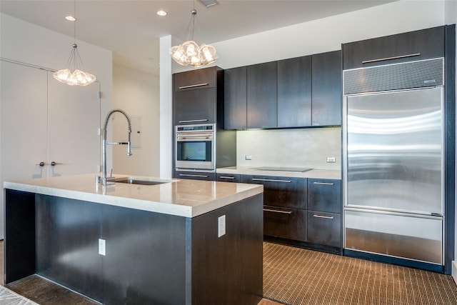 2200 Victory Ave Unit 701, Dallas, TX 75219 - kitchen with stainless steel appliances, a sink, a chandelier, hanging light fixtures, and an island with sink