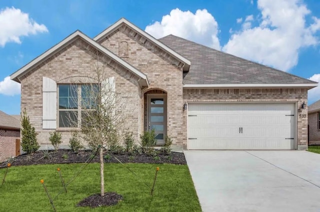 533 Hillcrest Cir, Justin, TX 76247 - view of front facade with brick siding, a garage, concrete driveway, a front lawn, and a shingled roof