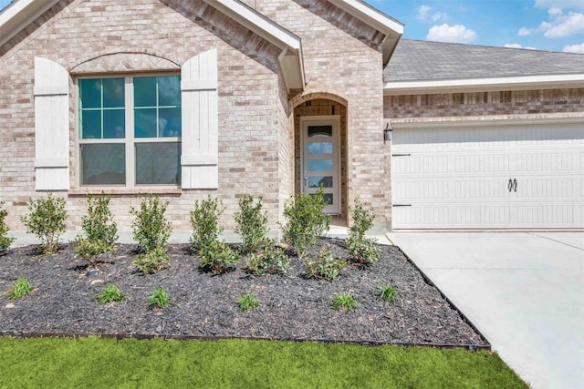 533 Hillcrest Cir, Justin, TX 76247 - view of exterior entry with an attached garage, driveway, and brick siding