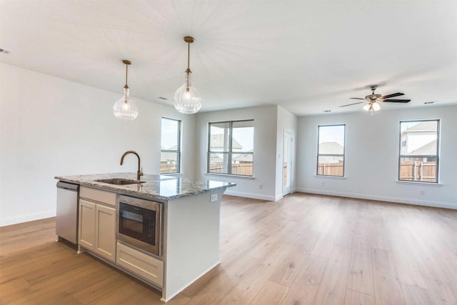 533 Hillcrest Cir, Justin, TX 76247 - kitchen featuring dishwasher, built in microwave, a sink, a center island with sink, and light wood-style flooring